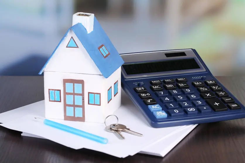 Toy house and calculator on table close-up