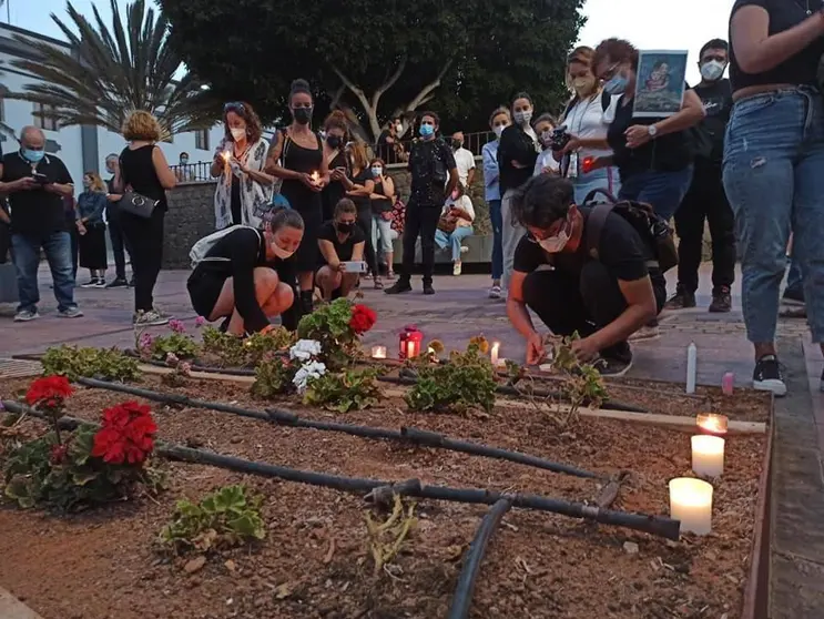 Gente poniendo velas durante la concentración