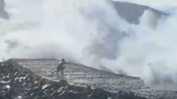 Un joven intenta sacar una  foto demasiado cerca de la costa con fort&iacute;simo oleaje