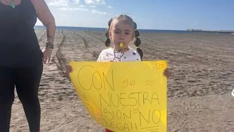 Una niña portando una pancarta