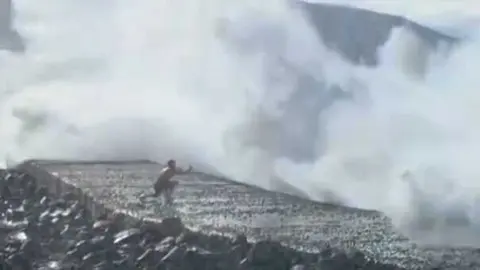 Un joven intenta sacar una  foto demasiado cerca de la costa con fort&iacute;simo oleaje